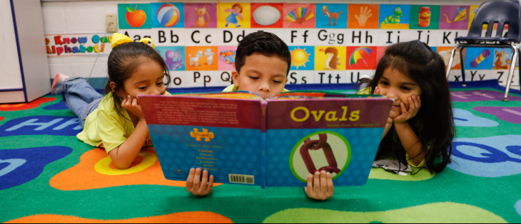 Students reading a book together 